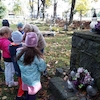 Pamiętając o zmarłych uczniowie świetlicy zapalają znicze na cmentarzu.